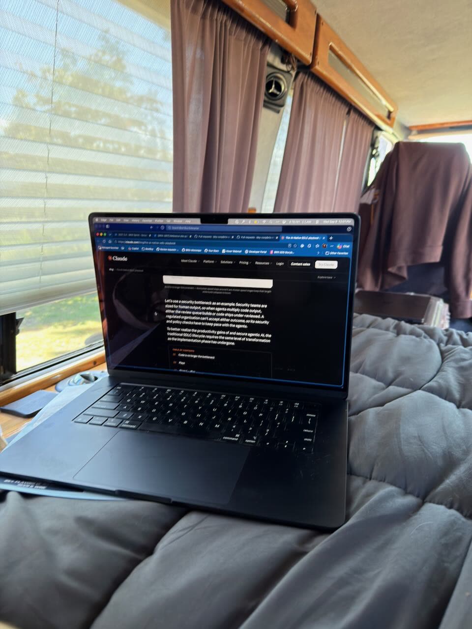 A laptop open on the bed in the van